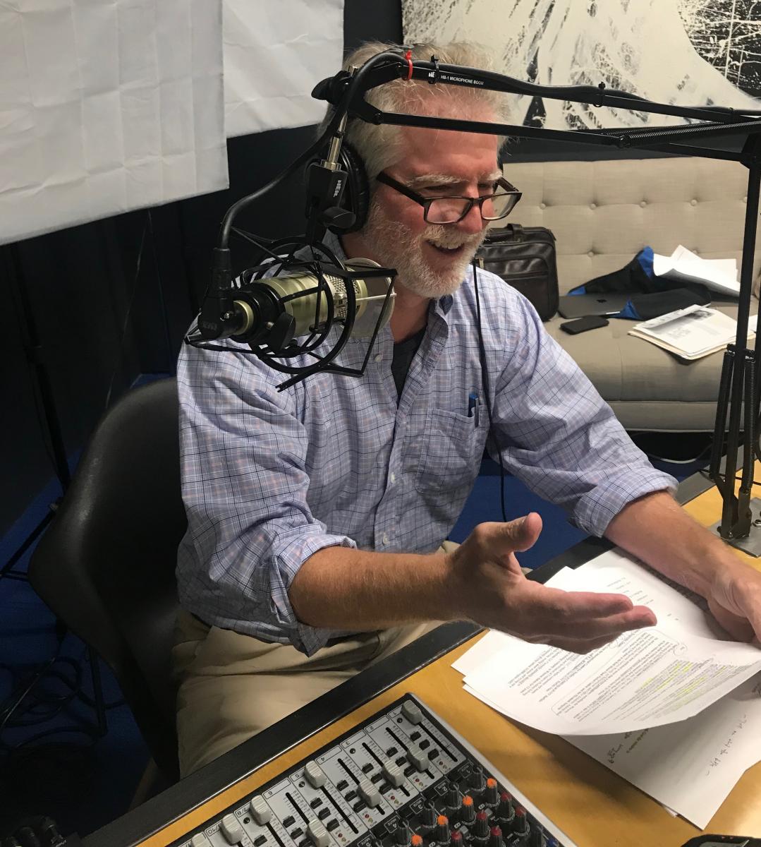 This is a picture of Landis Wade wearing headphones and sitting in a recording studio. He has white hair and there is a white background.